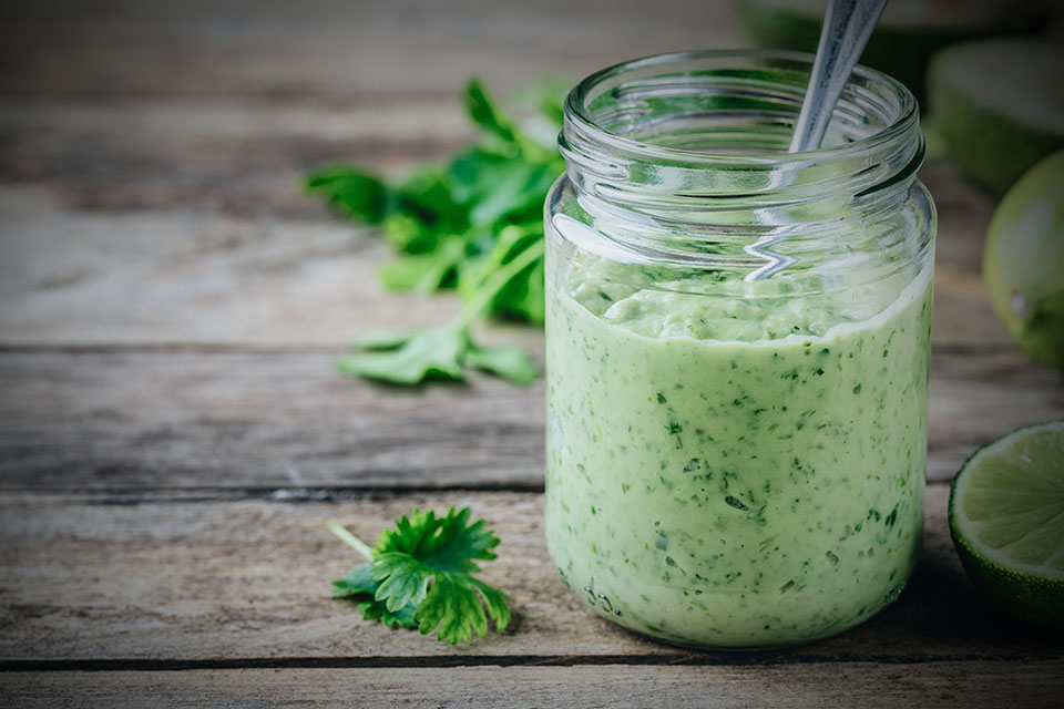 green salad dressing with avocado, lime and cilantro in a glass