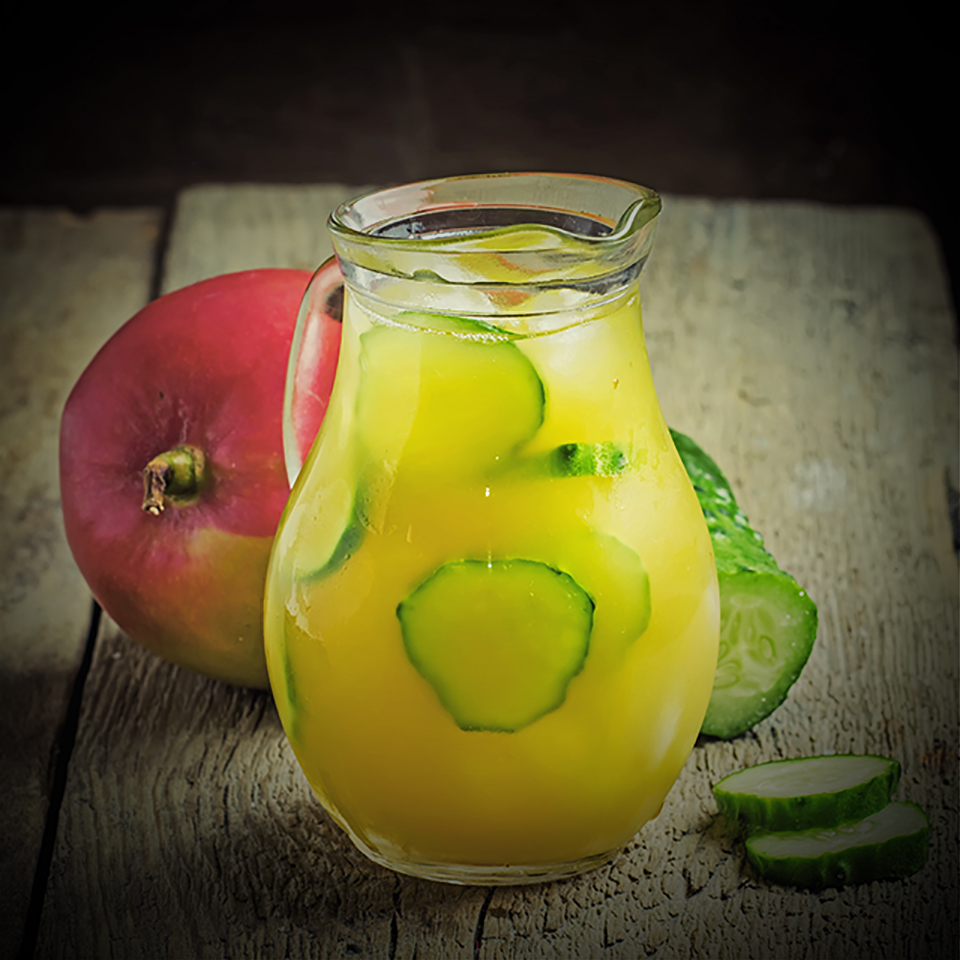Vitamin lemonade in a jug, with syrup, juice, mango, cucumber an